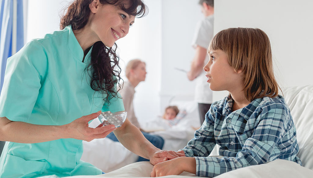 A Nurse Smiling While Giving Medication to a Child Sitting in a Bed Holistic Pediatric Hospice Care