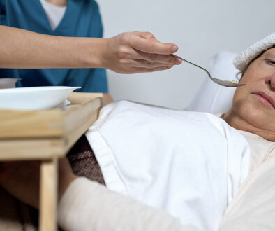 A Terminally Ill Woman Turning Her Face Away From a Spoon of Food Being Served by a Nurse Hospice Patient Not Eating