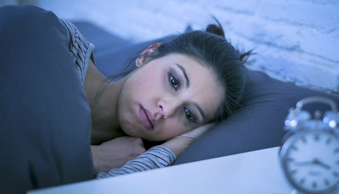 Closeup Of A Woman Laying In Bed At Night Looking Sad Experiencing The Physical Effects Of Grief