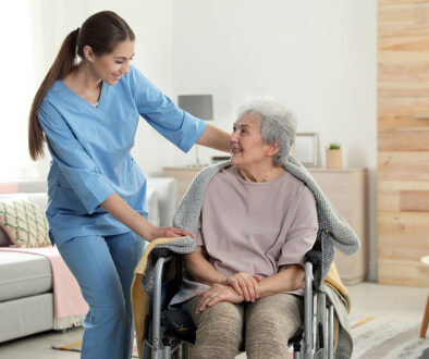 A Hospice Nurse Putting a Blanket on a Senior Woman Sitting in a Wheelchair Hospice and Parkinson’s Disease